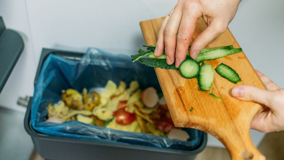 Food waste peelings being scraped into a bin