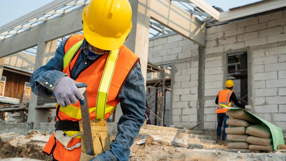 Man wearing an orange high vis at a construction site