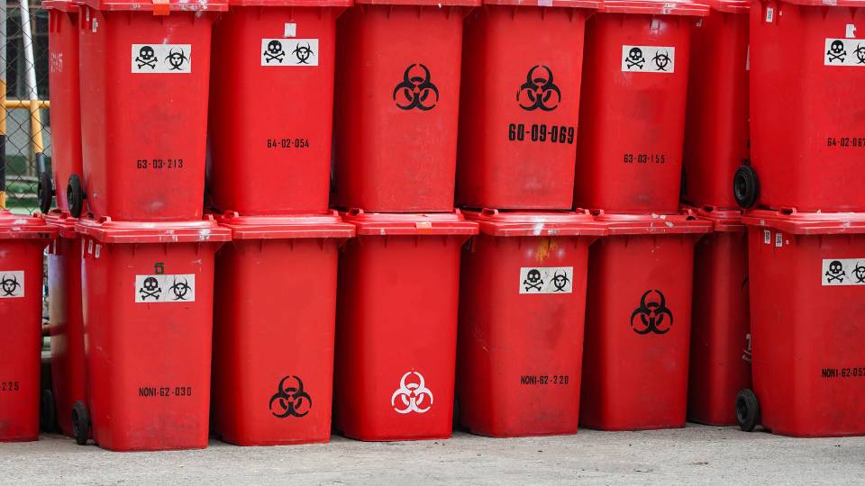 Red hazardous waste wheelie bins