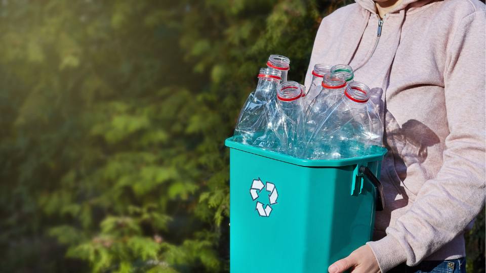 worker carrying recycling bin