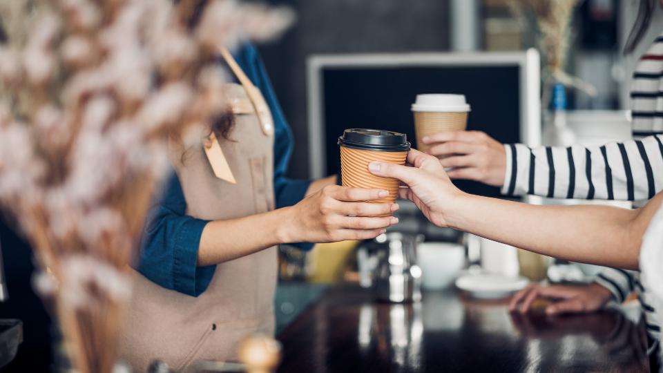 barista serving coffee in a cafe