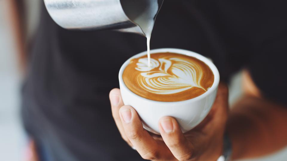 a barista doing latte art in a cafe