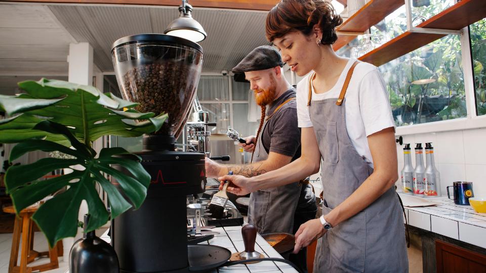 two baristas serving coffees in a cafe