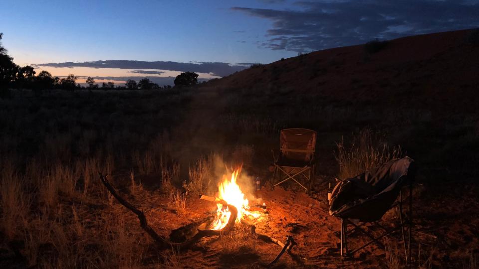 campsite with a fire and folding camping chairs