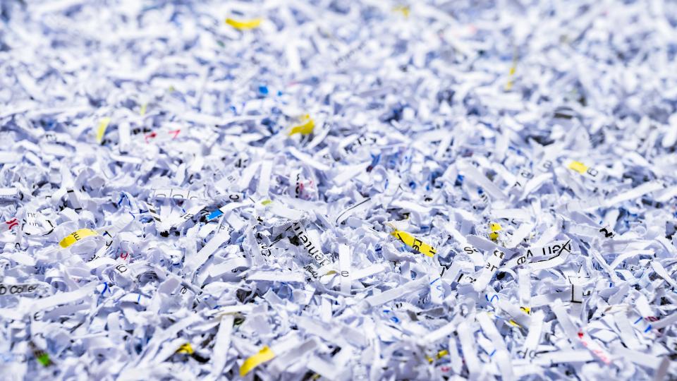An image of confidential waste. there is some shredded paper ready to be disposed of.