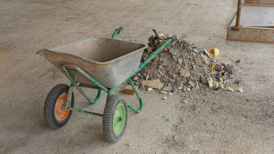 Photograph of some inert waste on the ground with a wheelbarrow on a construction site