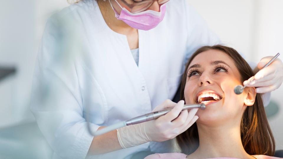 A photograph of a dentist with a smiling patient. 