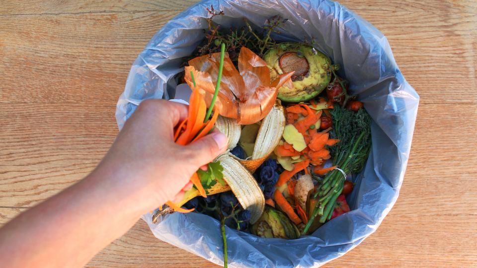 A photograph of food waste going into the food waste bin. 