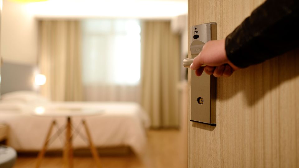 A concierge opening a hotel room door