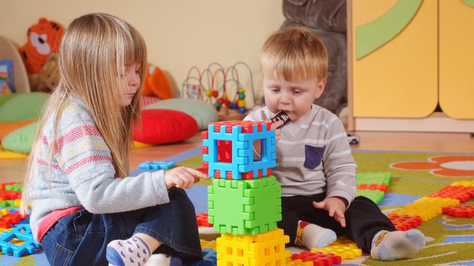 two children playing with nursery educational toys