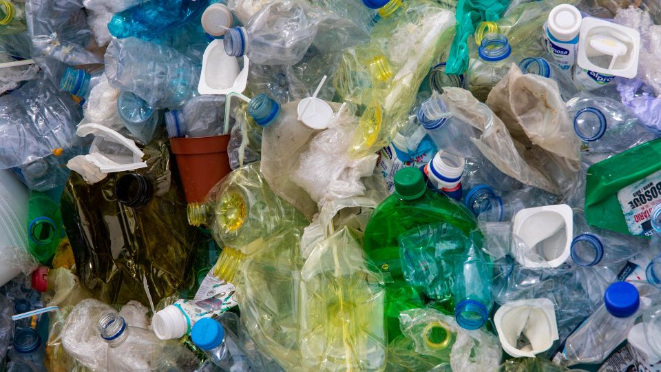A photograph of some crumpled plastic bottles and other types of plastic waste.
