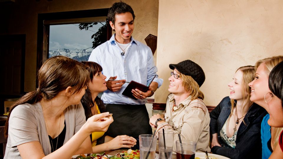 photograph of a waiter taking an order at a restaurant