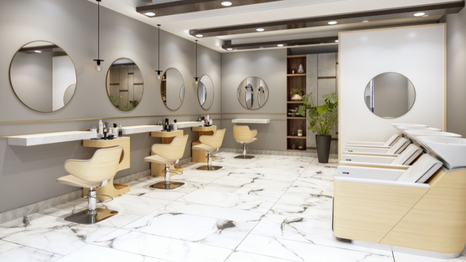 Photograph of a beauticians salon. There are mirrors for the hair dressing station and seats with sinks to get the clients hair washed in. 