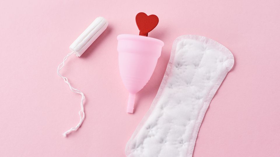 photograph of female sanitary products including a pad, menstrual cup and tampon