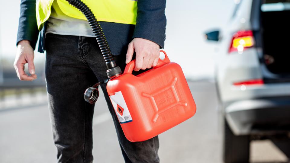 Man holding red plastic petrol container