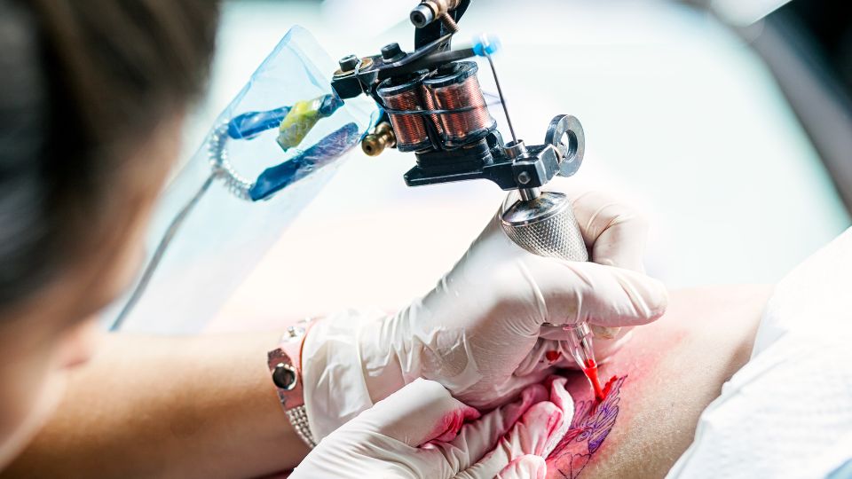 Tattoo artist tattooing a customer