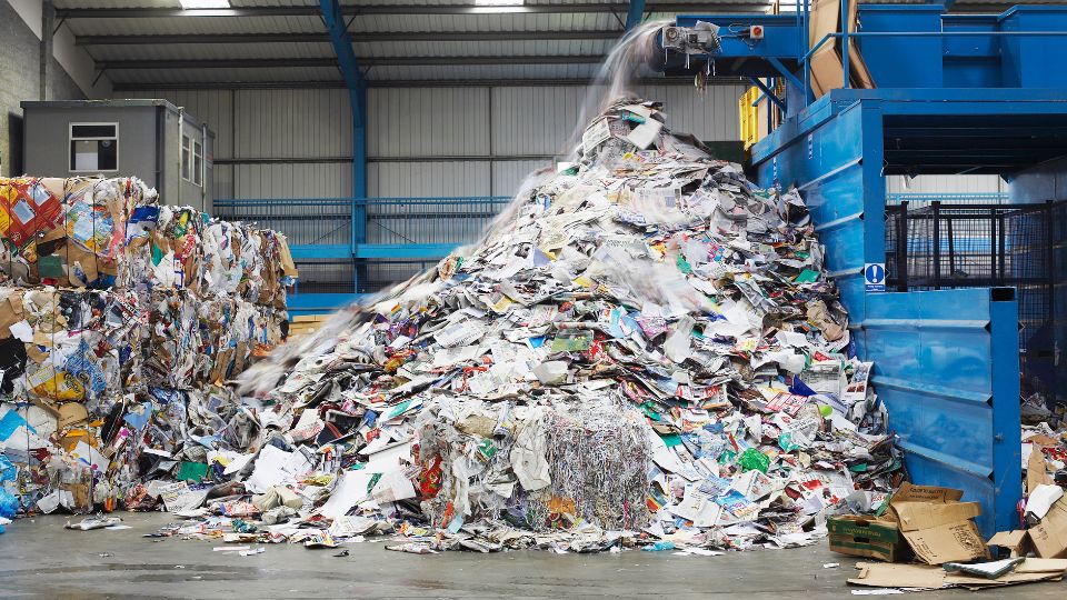 photograph of industrial recycling stack of newspapers machine