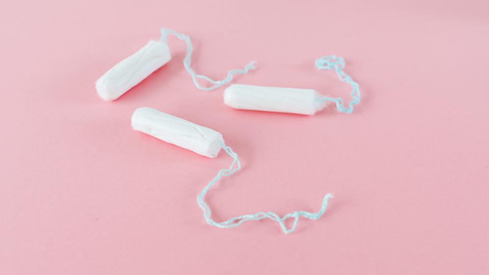 three individual tampons on a pink background 