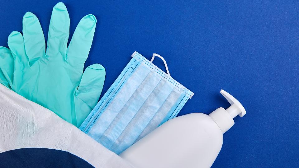 PPE including gloves and masks on a blue background