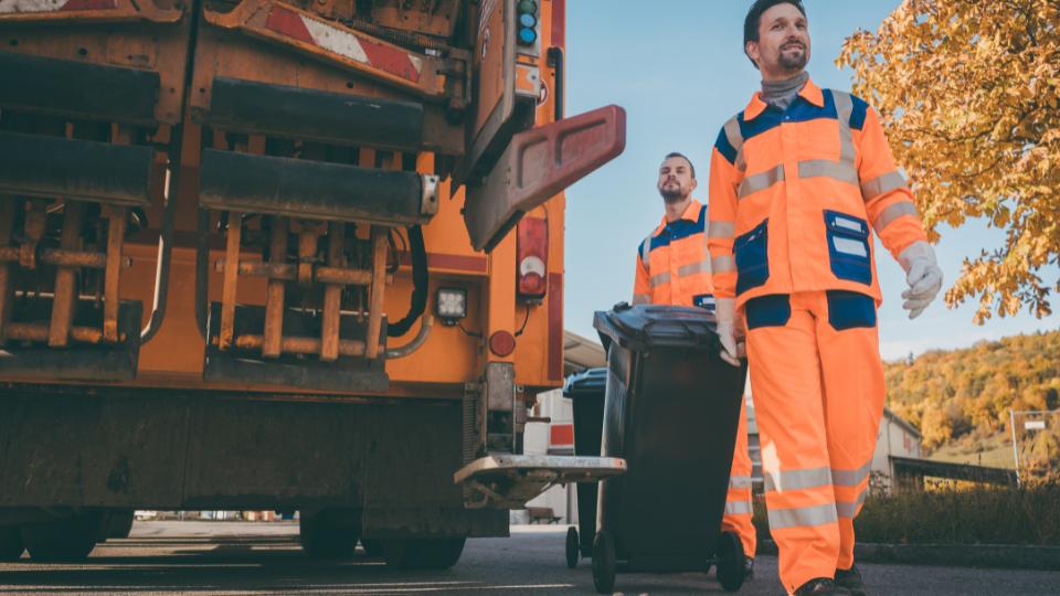 Business wheelie bins being taken to a waste collection truck