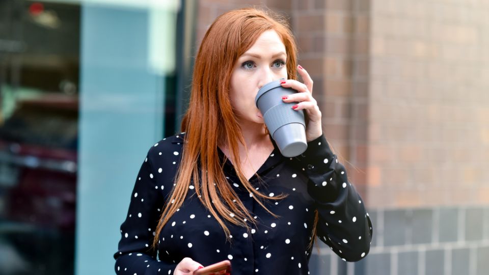 woman drinking coffee from reusable coffee cup from zero waste bakery